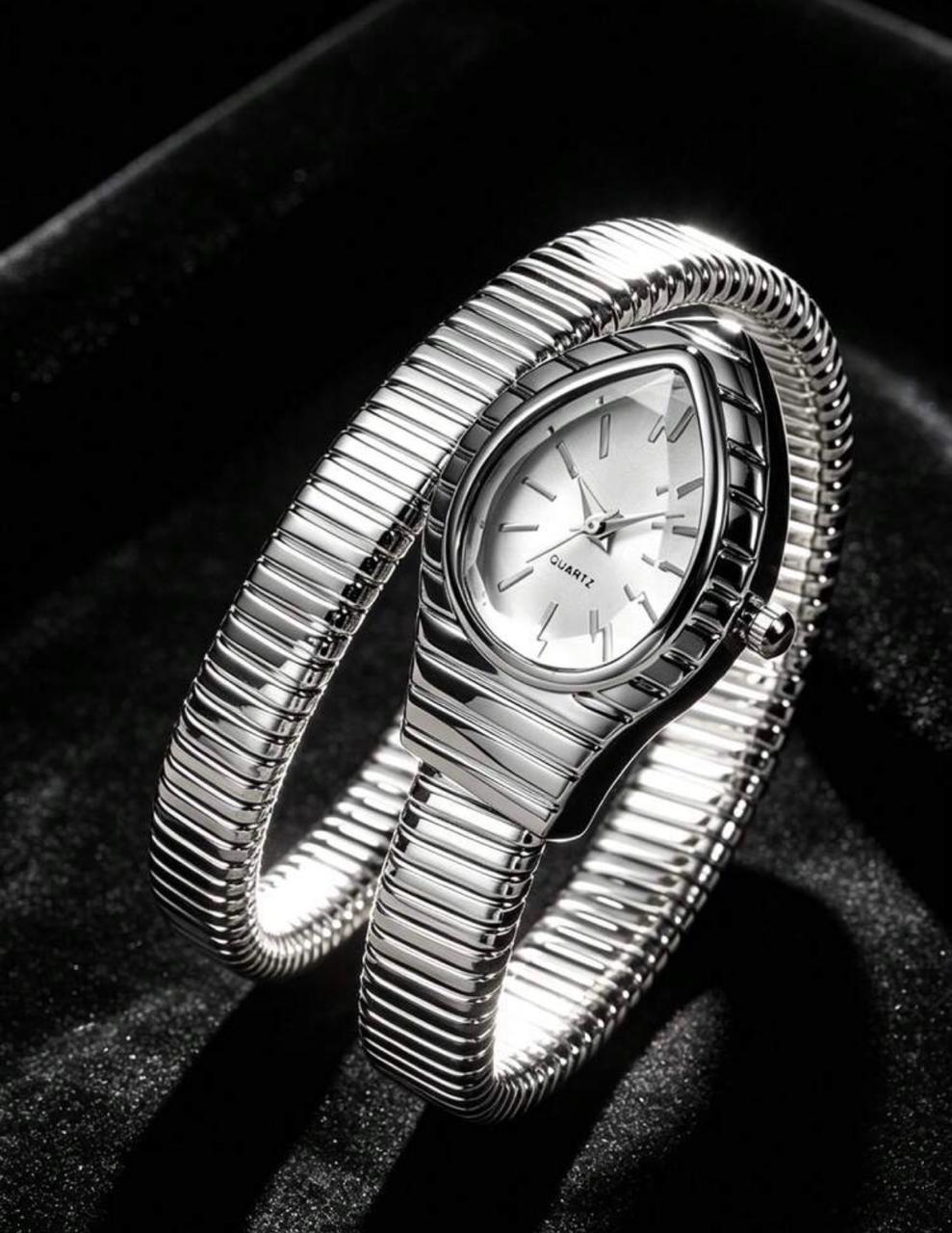 silver plated snake watch with coiled ribbed strap and white teardrop dial on black velvet