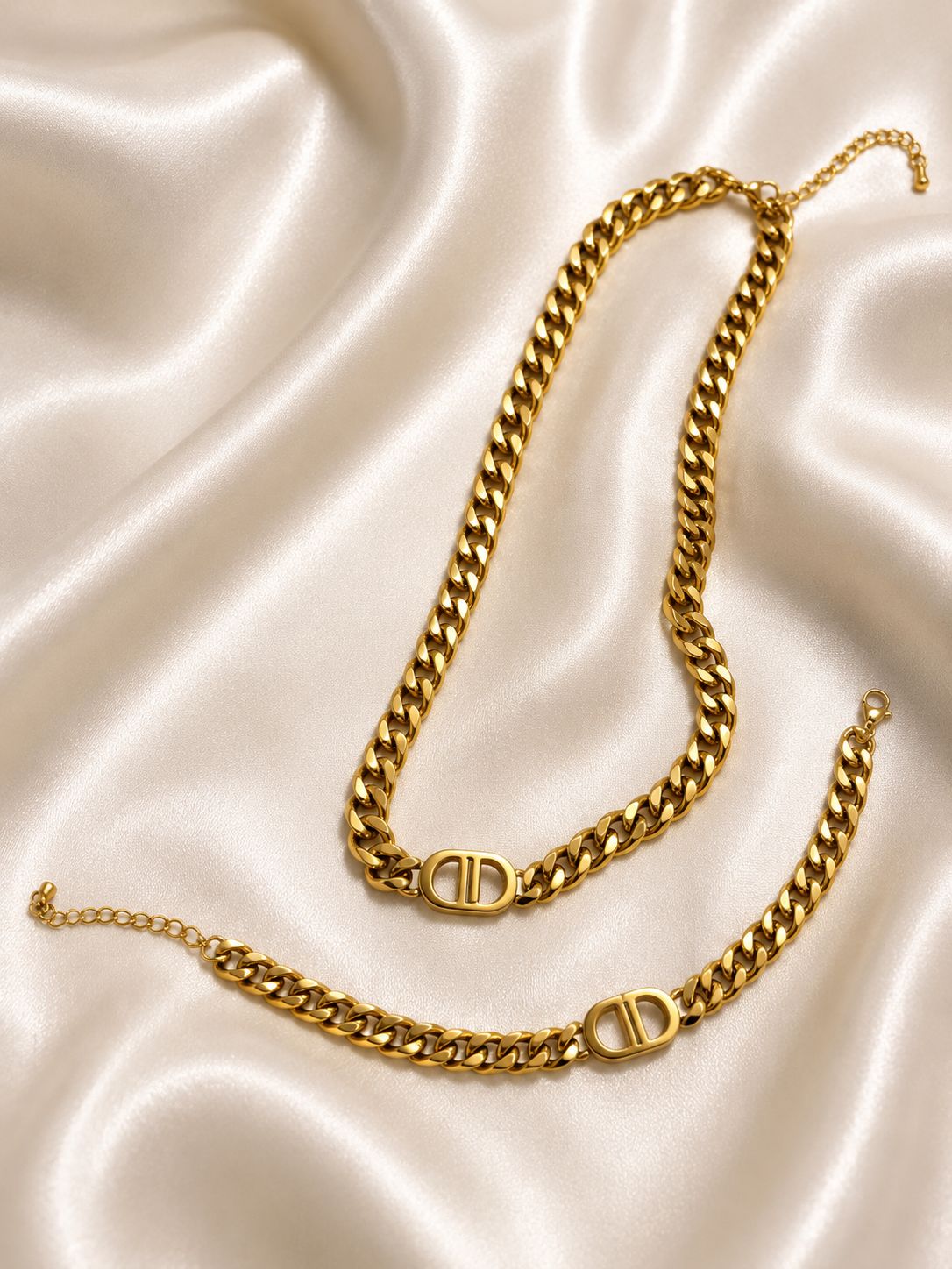 DD gold bracelet and chain set hypoallergenic on satin fabric