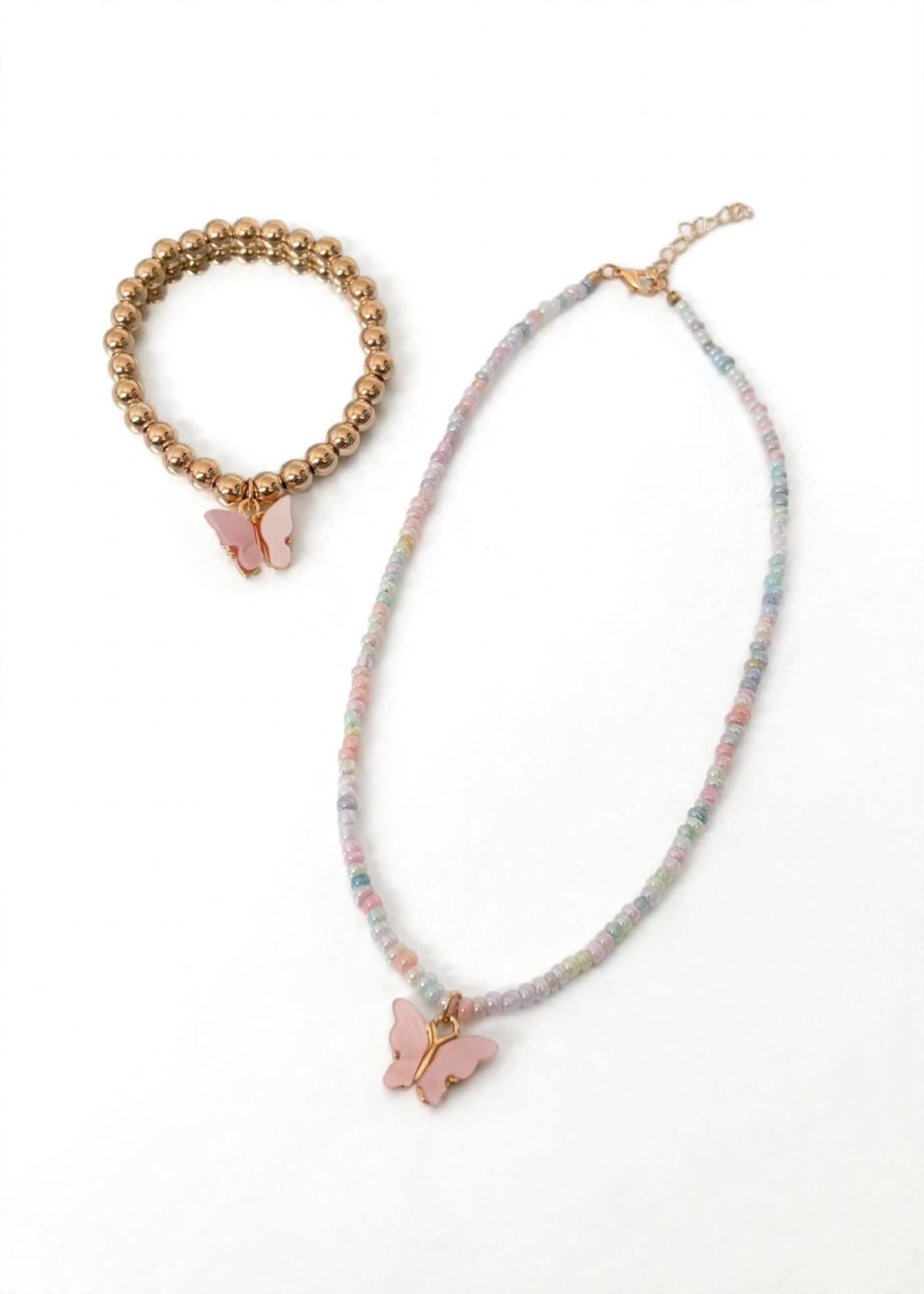 kids pastel bead necklace and gold-tone bead bracelet with pink butterfly charms on white background